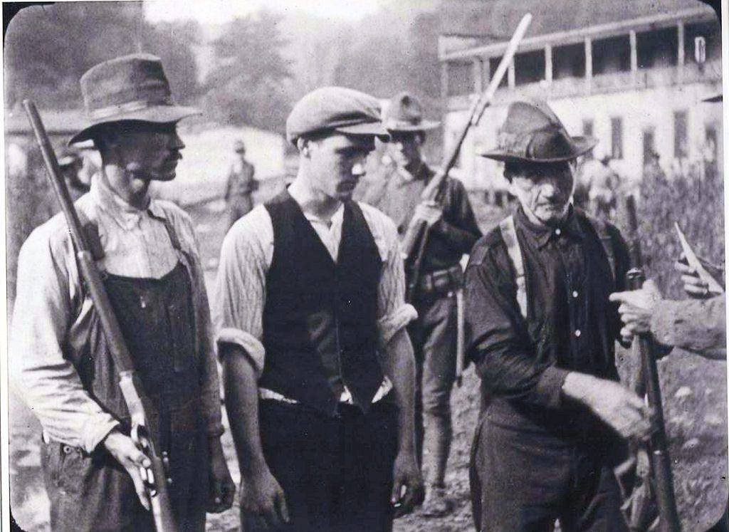 Union miners surrendering rifles to federal soldiers after the Battle of Blair Mountain in 1921.