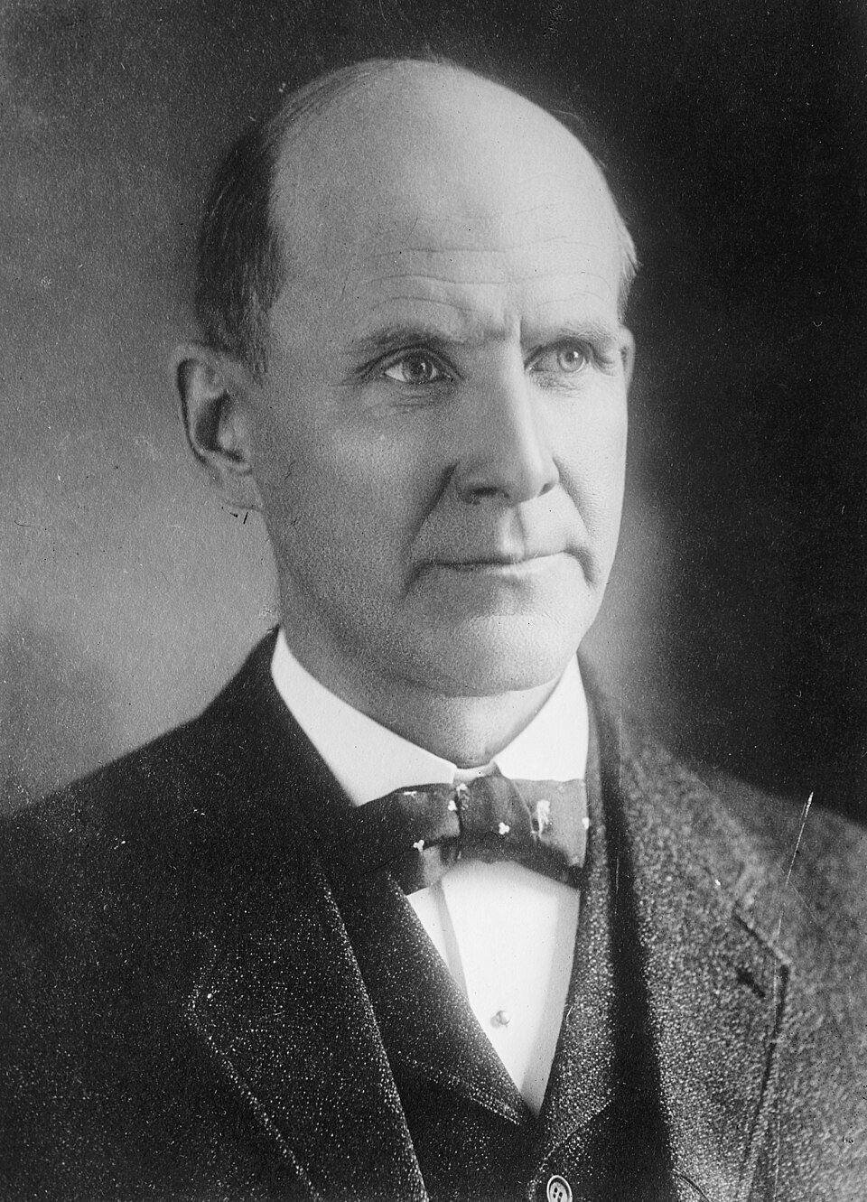 Formal seated portrait of Eugene V. Debs in a dark suit and bow tie.