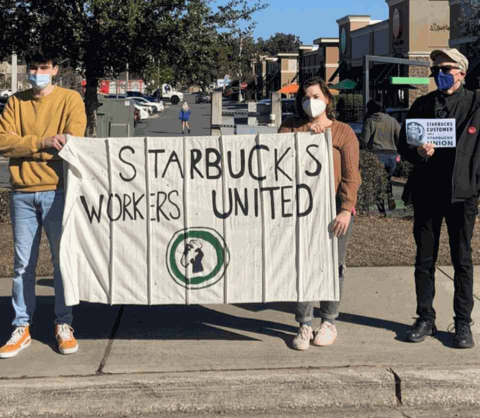 Starbucks Workers United supporters holding union signs during a 2022 protest in Tallahassee, Florida.