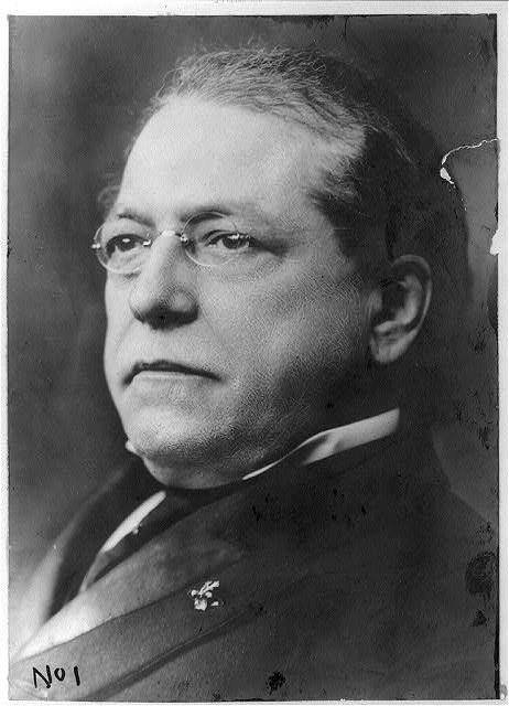 Head-and-shoulders portrait of Samuel Gompers wearing glasses.